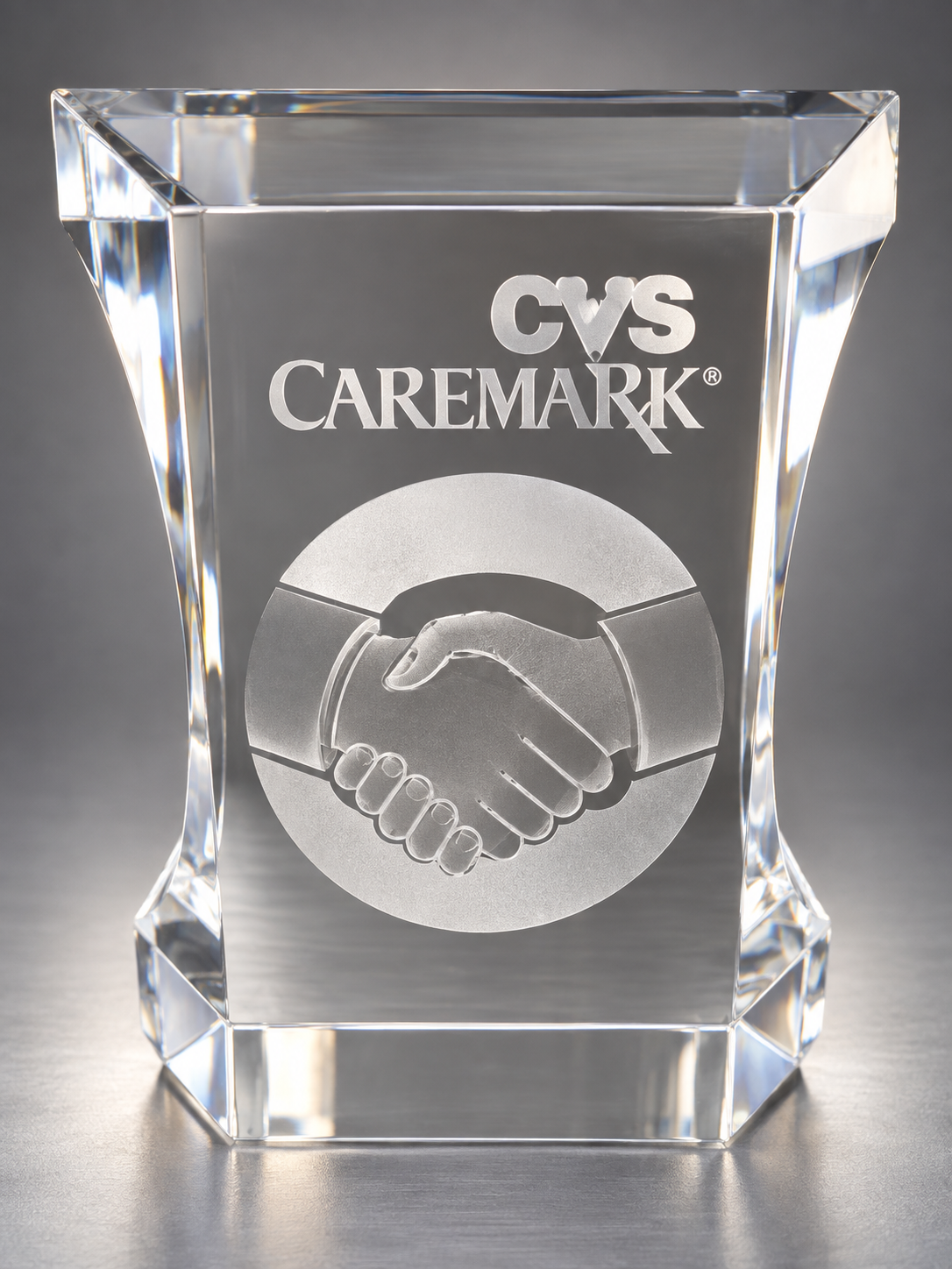 CVS Caremark crystal trophy with a handshake emblem from AJ Khubani’s collection