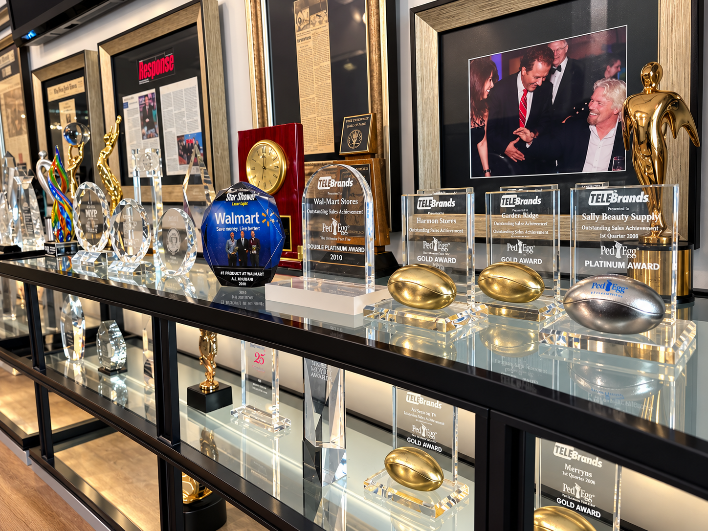 TeleBrands product and retail milestone displays, including PedEgg plaques presented to retail partners
